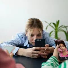 Młodzi ludzie pochłonięci smartfonami, być może doświadczający nomofobii. Co to za zjawisko?