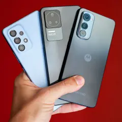Dłoń trzyma trzy smartfony: jasnoniebieski, szary i ciemnoszary z logo Motorola. Kraj pochodzenia tej marki to USA.
