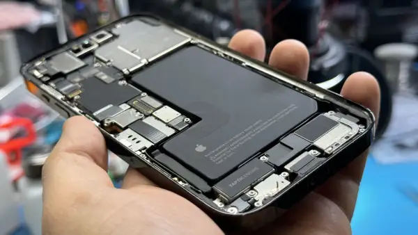 Wnętrze iPhone'a z widoczną baterią i elementami płyty głównej. Czas sprawdz port ładowania USB.